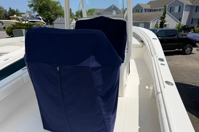 Slide: The Image of 2015 Regulator 23 Center Console boat with blue covers, docked in a marina. - 10