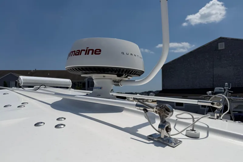 Slide: The Image of 2015 Regulator 23 Center Console boat with Raymarine radar on deck under blue sky. - 23