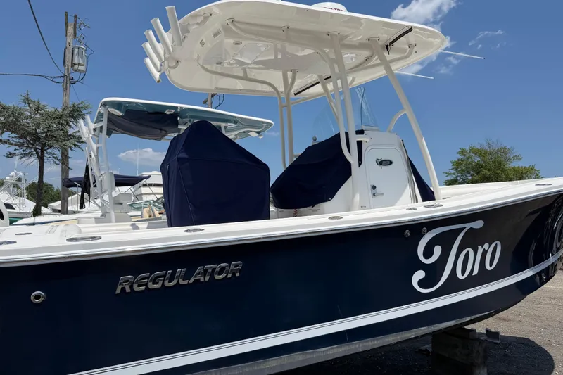 The Image of 2015 Regulator 23 Center Console boat named "Toro" docked under clear blue sky. - 1