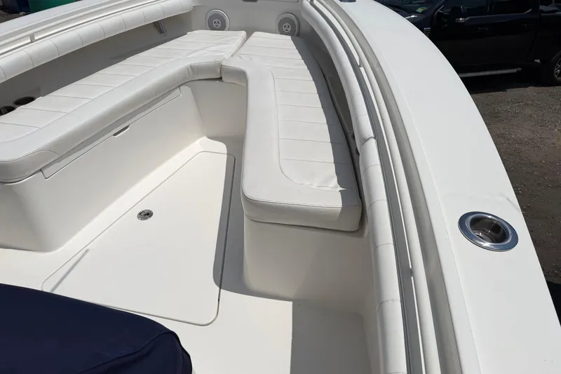Slide: The Image of 2015 Regulator 23 Center Console boat with white cushioned seating and cup holders. - 28