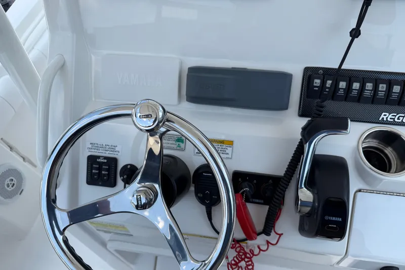 Slide: The Image of 2015 Regulator 23 Center Console boat helm with Yamaha controls and steering wheel. - 16