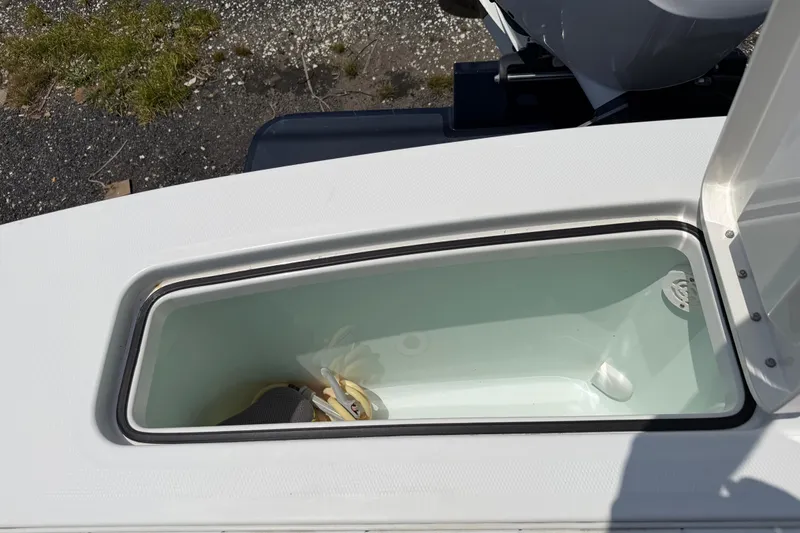 Slide: The Image of 2015 Regulator 23 Center Console boat storage compartment with open lid. - 9