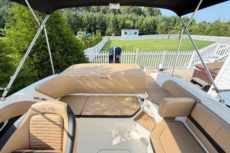 Slide: The Image of 2024 Sea Ray SPX 190 Outboard boat interior with tan seating and canopy. - 9