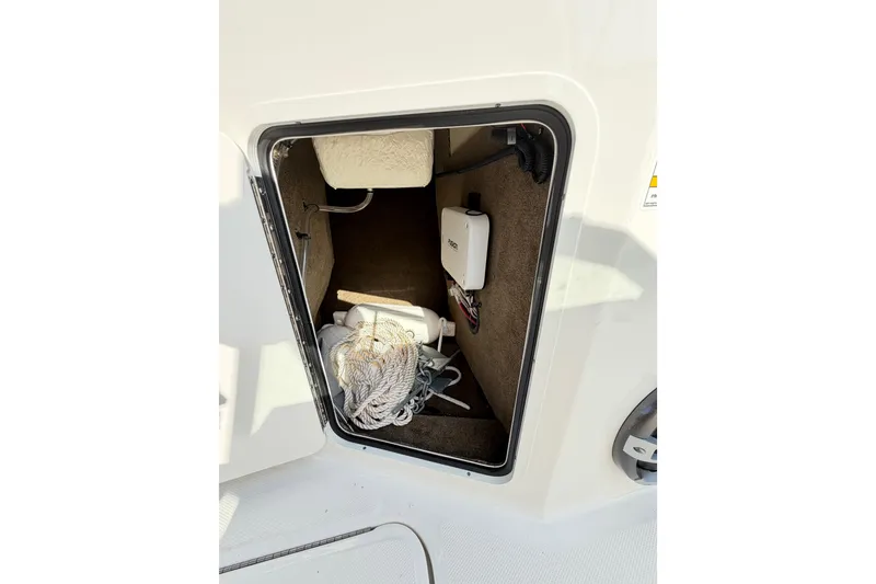 Slide: The Image of Storage compartment of 2024 Sea Ray SPX 190 Outboard with rope and equipment. - 30