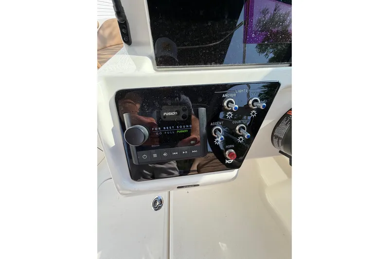 Slide: The Image of 2024 Sea Ray SPX 190 Outboard dashboard with Fusion audio controls and switches. - 25