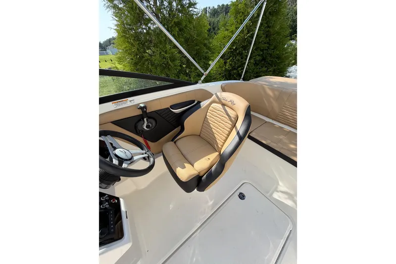 Slide: The Image of 2024 Sea Ray SPX 190 Outboard boat interior with tan seating and steering wheel. - 13
