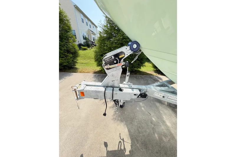 Slide: The Image of 2024 Sea Ray SPX 190 Outboard trailer hitch on driveway, surrounded by greenery. - 43