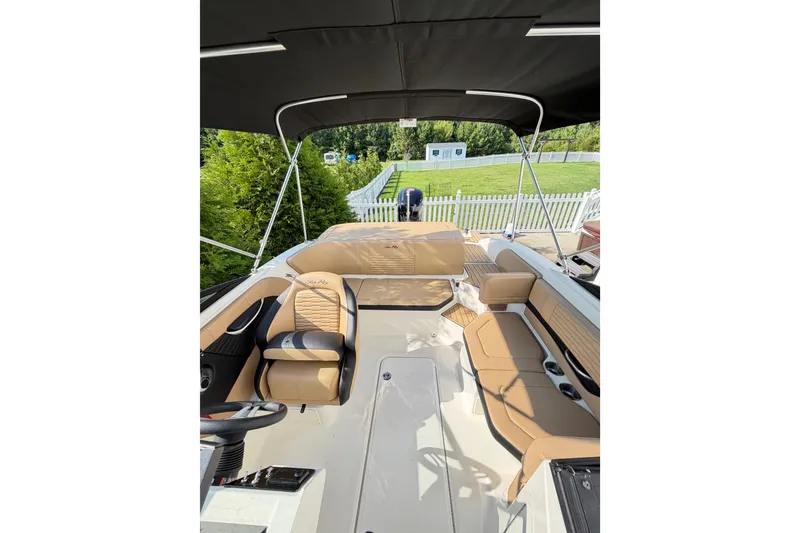 Slide: The Image of 2024 Sea Ray SPX 190 Outboard boat interior with tan seating and canopy. - 16