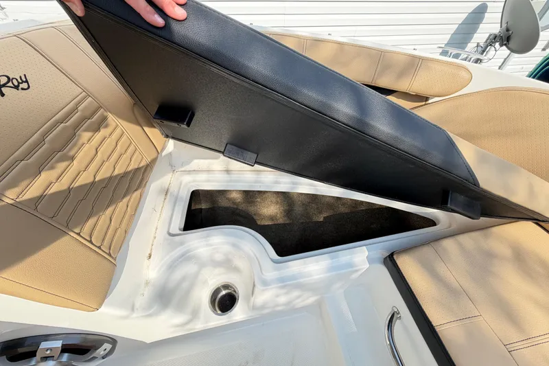 Slide: The Image of 2024 Sea Ray SPX 190 Outboard boat storage compartment with beige seating and black lid. - 27