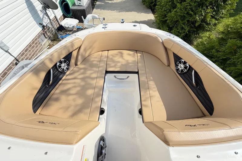 Slide: The Image of 2024 Sea Ray SPX 190 Outboard boat interior with tan seating and built-in speakers. - 7