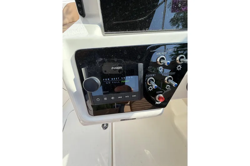 Slide: The Image of 2024 Sea Ray SPX 190 Outboard dashboard with Fusion audio system and control panel. - 24