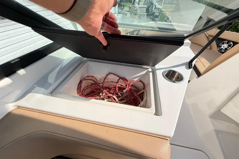 Slide: The Image of 2024 Sea Ray SPX 190 Outboard boat storage compartment with ropes and cup holder. - 37