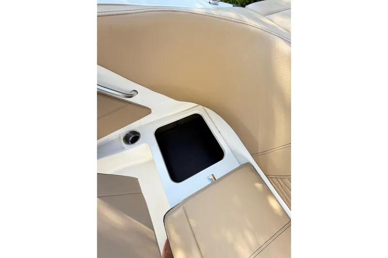 Slide: The Image of 2024 Sea Ray SPX 190 Outboard interior detail with beige seating and storage compartment. - 33