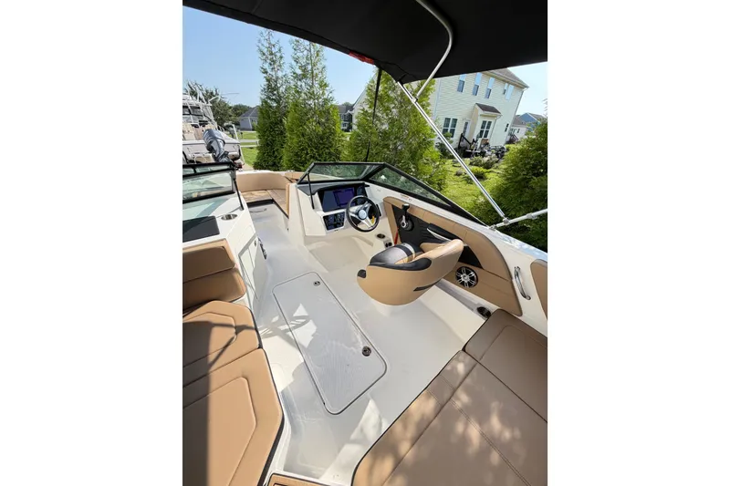 Slide: The Image of 2024 Sea Ray SPX 190 Outboard boat interior with tan seating and modern dashboard. - 11