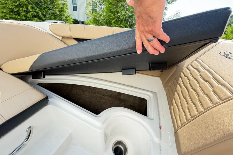 Slide: The Image of 2024 Sea Ray SPX 190 Outboard storage compartment with cushioned seating and hand lifting cover. - 28