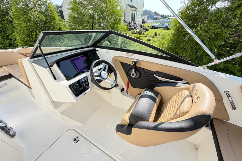 Slide: The Image of 2024 Sea Ray SPX 190 Outboard boat interior with tan seating and modern dashboard. - 12