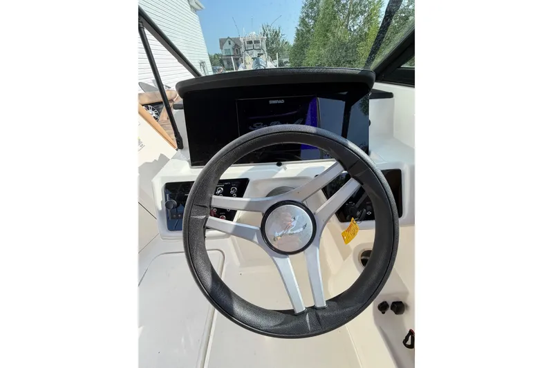 Slide: The Image of 2024 Sea Ray SPX 190 Outboard steering wheel and dashboard, featuring modern controls. - 20