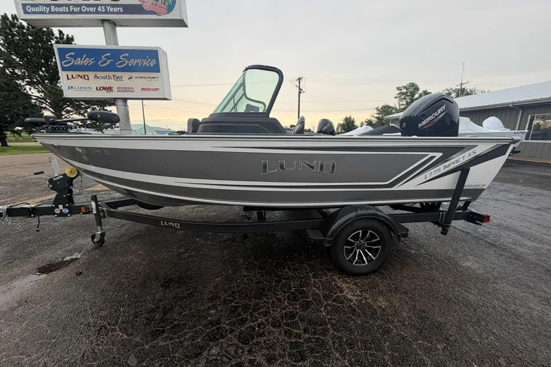 Slide: The Image of 2025 Lund 1775 Impact XS Sport boat on trailer at dealership. - 1