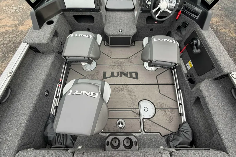 Slide: The Image of 2025 Lund 1775 Impact XS Sport boat interior with gray seating and steering console. - 6