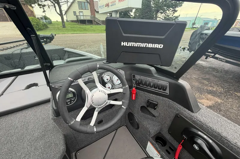 Slide: The Image of 2025 Lund 1775 Impact XS Sport boat dashboard with Humminbird display and steering wheel. - 5