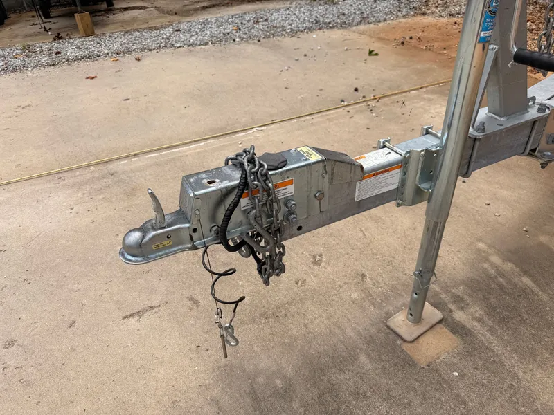 Slide: The Image of Close-up of a boat trailer hitch with chains and cables on a concrete surface. - 43