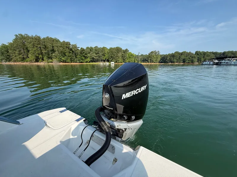 Slide: The Image of A 2023 Cobalt R6 outboard boat on calm water, surrounded by trees. - 14