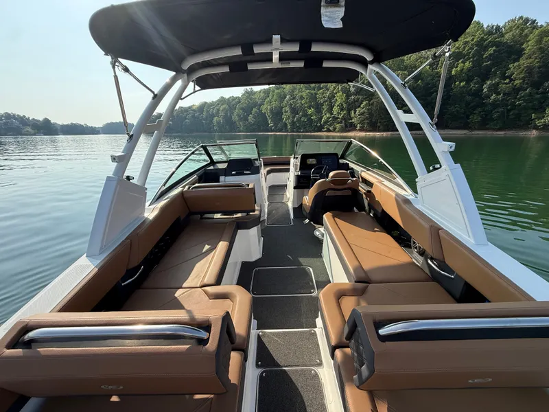 Slide: The Image of The image shows a 2023 Cobalt R6 Outboard boat with brown seating and a black canopy on a calm lake. - 18