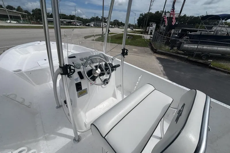 Slide: The Image of 2020 Glasstream 20 CCR boat interior with steering wheel and seating, parked outdoors. - 23