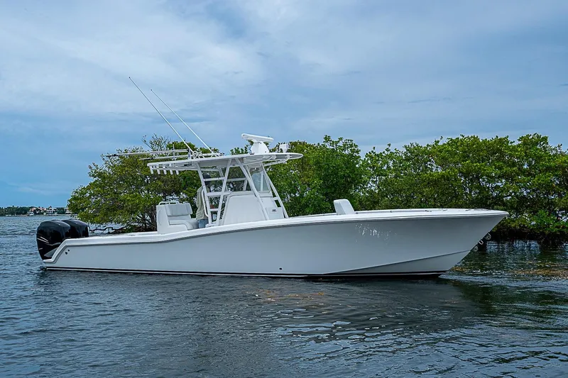 Slide: The Image of 2018 Invincible 33 Open Fisherman boat on calm water, surrounded by lush greenery. - 39