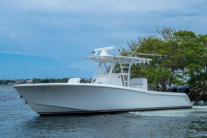 Slide: The Image of 2018 Invincible 33 Open Fisherman boat cruising on calm waters near lush greenery. - 50