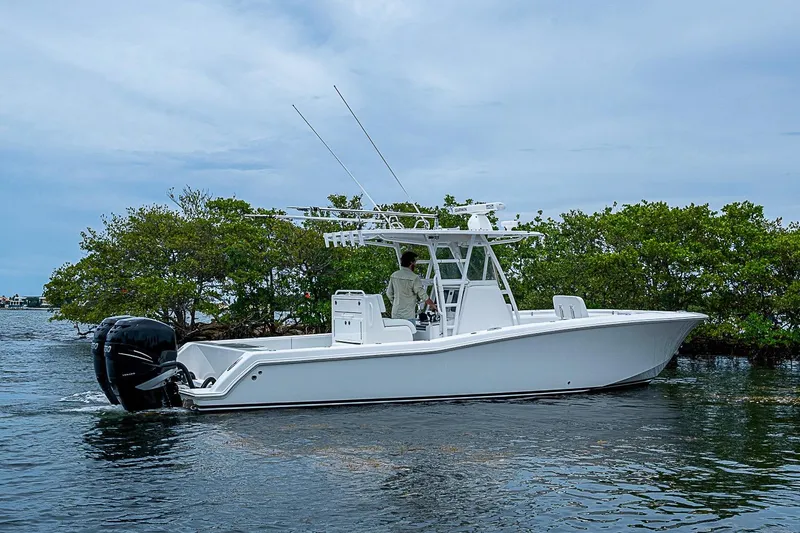 Slide: The Image of 2018 Invincible 33 Open Fisherman boat cruising near lush mangroves under a cloudy sky. - 41