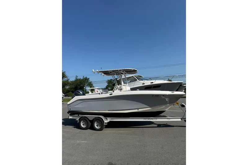 Slide: The Image of 2022 Robalo R200 Center Console boat on trailer under clear blue sky. - 7