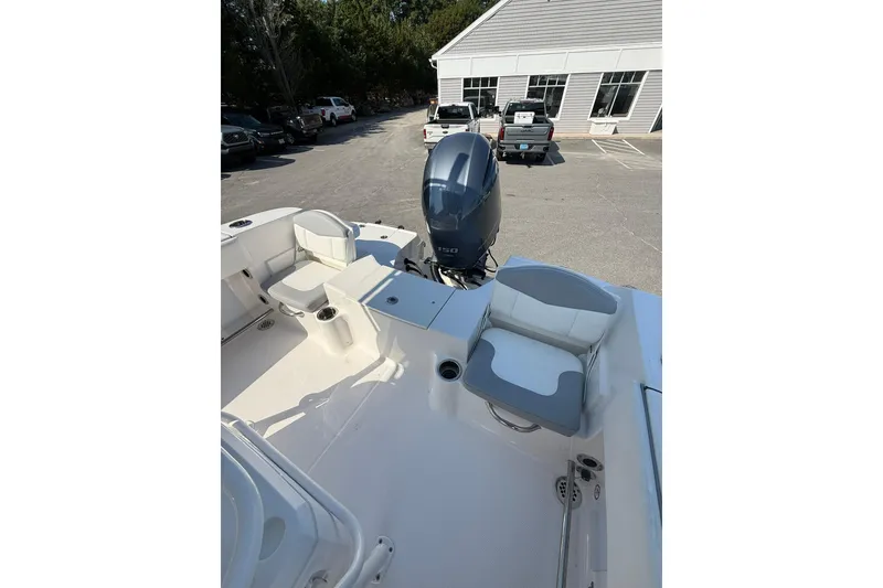 Slide: The Image of 2022 Robalo R200 Center Console boat with seating and outboard motor in a parking lot. - 10