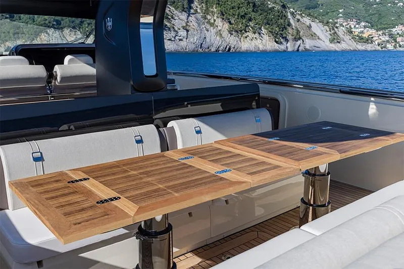Slide: The Image of Luxury yacht Invictus 470 (2025) with elegant wooden table and scenic ocean view. - 1