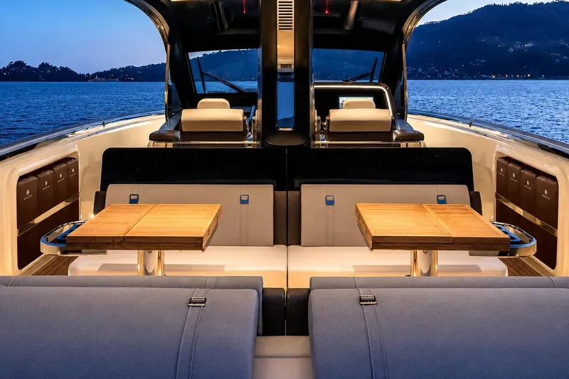 Slide: The Image of Luxurious 2025 Invictus 470 yacht interior with elegant seating and wooden tables at sunset. - 5