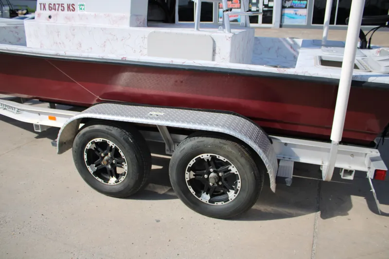 Slide: The Image of 2022 Shoalwater 20' Catamaran on trailer, featuring dual black wheels and maroon hull. - 18