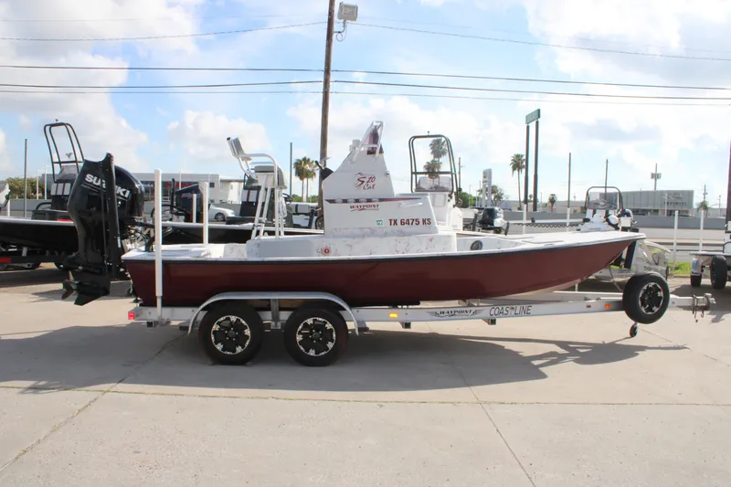 Slide: The Image of 2022 Shoalwater 20' Catamaran on trailer, parked outdoors under a partly cloudy sky. - 1