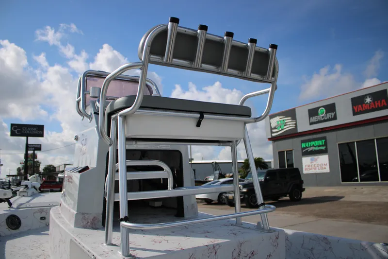 Slide: The Image of 2022 Shoalwater 20' Catamaran with fishing rod holders, parked near marine dealership. - 15