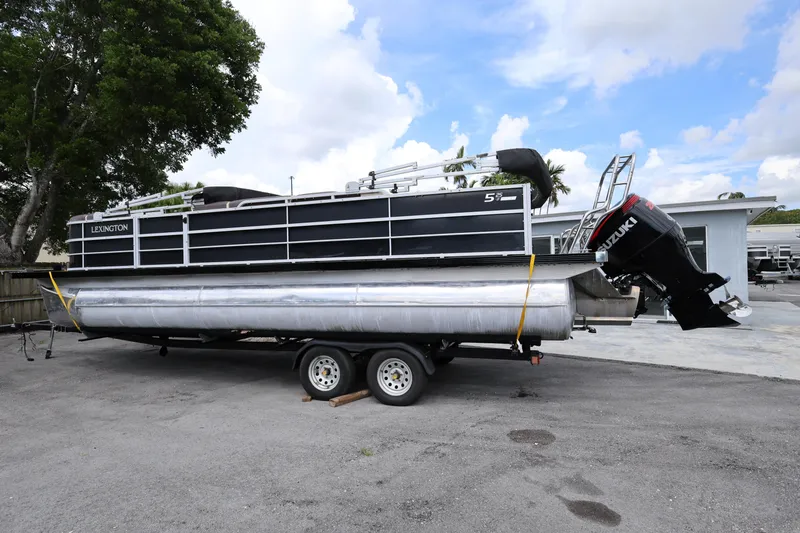 Slide: The Image of 2021 Lexington 525 Series 5 pontoon boat on trailer, featuring Suzuki outboard motor. - 4
