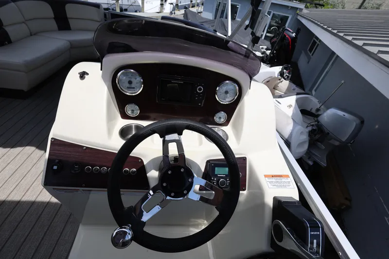 Slide: The Image of Steering console of a 2021 Lexington 525 Series 5 boat, featuring modern controls and gauges. - 22