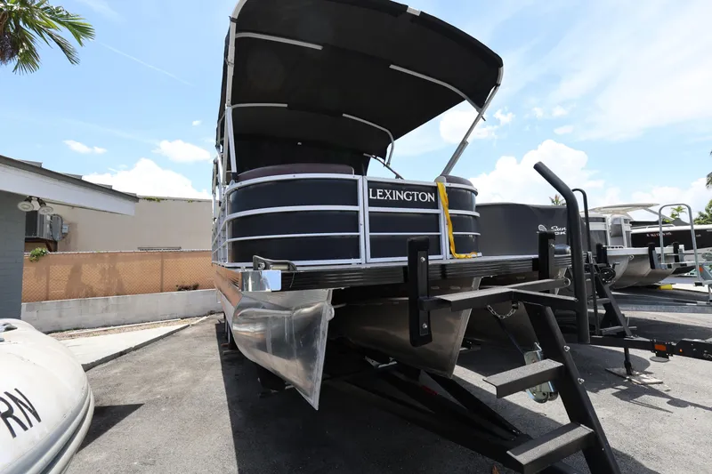 Slide: The Image of 2021 Lexington 525 Series 5 pontoon boat on trailer under clear blue sky. - 6