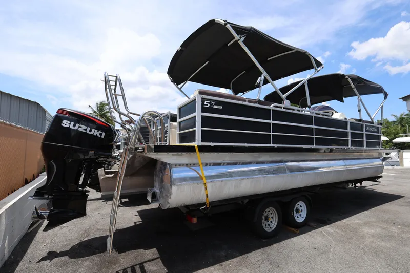 Slide: The Image of 2021 Lexington 525 Series 5 pontoon boat with Suzuki outboard motor on trailer. - 5