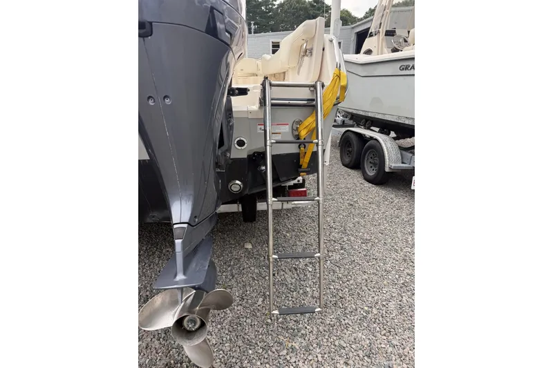 Slide: The Image of 2020 Grady-White Fisherman 257 boat with ladder and outboard motor on gravel. - 31