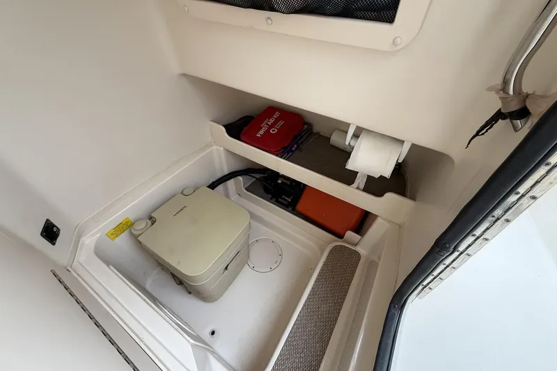 Slide: The Image of 2020 Grady-White Fisherman 257 boat interior with portable toilet and storage area. - 20