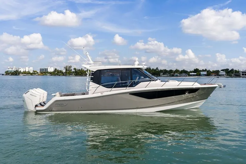 Slide: The Image of 2024 Boston Whaler 405 Conquest boat on calm water under a blue sky. - 9