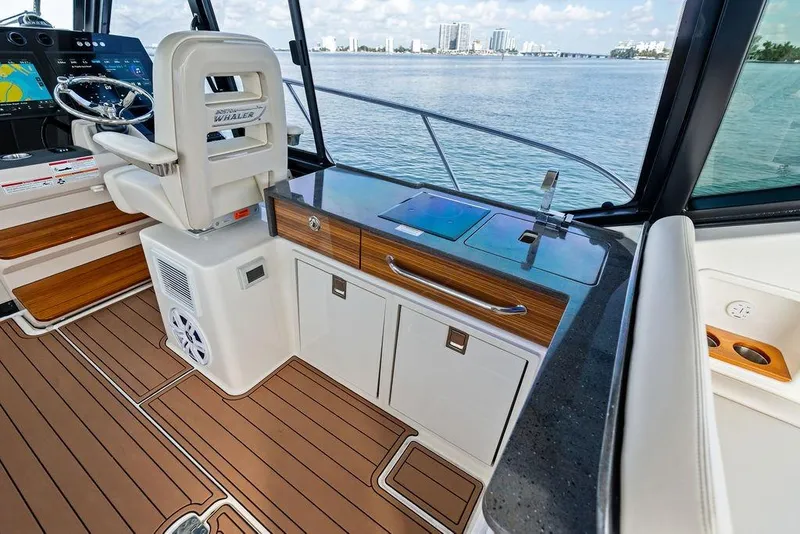 Slide: The Image of 2024 Boston Whaler 405 Conquest interior with helm, sink, and ocean view. - 37