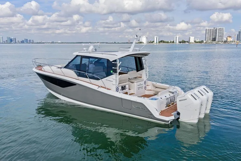 Slide: The Image of 2024 Boston Whaler 405 Conquest boat on calm water with city skyline background. - 4