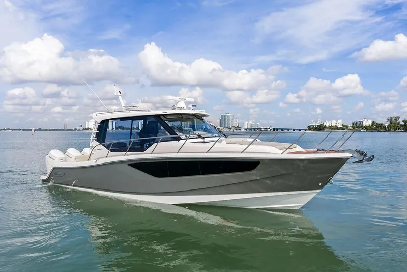 Slide: The Image of 2024 Boston Whaler 405 Conquest boat on calm water under a blue sky. - 12