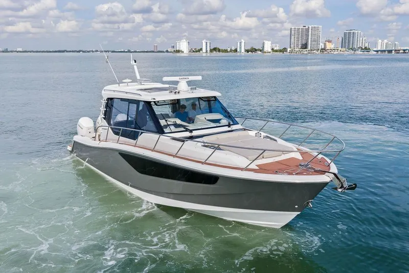 Slide: The Image of 2024 Boston Whaler 405 Conquest cruising on calm waters near a city skyline. - 11