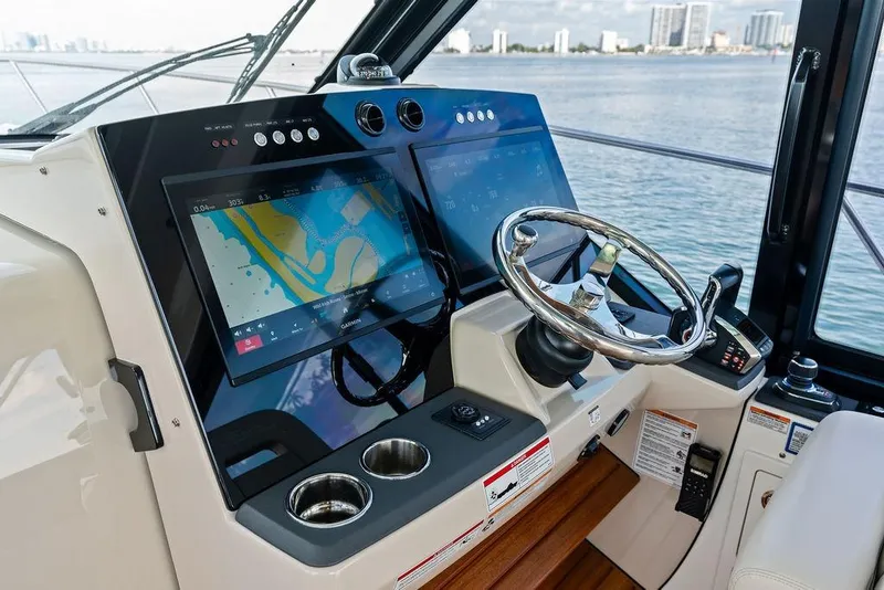 Slide: The Image of Helm of 2024 Boston Whaler 405 Conquest with dual navigation screens and steering wheel. - 34